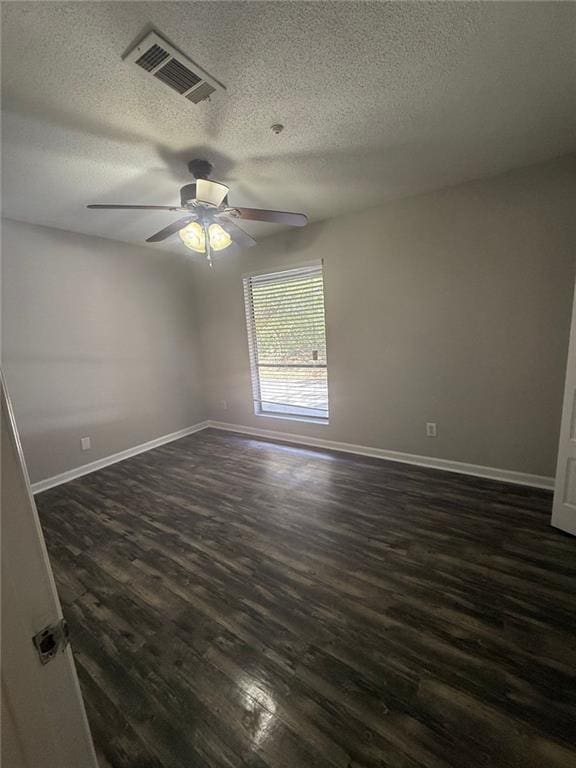 empty room featuring ceiling fan, dark hardwood / wood-style floors, and a textured ceiling