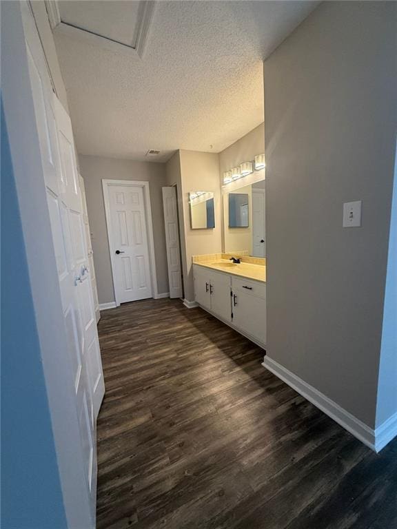 bathroom with hardwood / wood-style flooring, vanity, and a textured ceiling