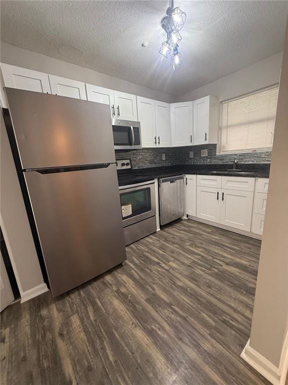 kitchen with white cabinetry, sink, dark hardwood / wood-style floors, and appliances with stainless steel finishes