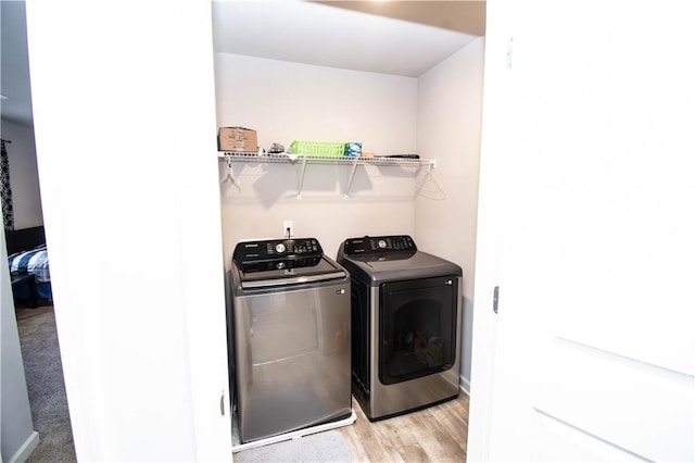 laundry room featuring washer and clothes dryer and light wood-type flooring