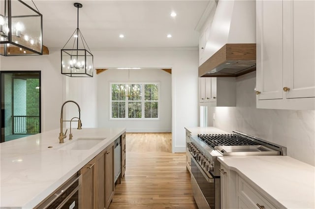 kitchen with white cabinetry, stainless steel appliances, and range hood