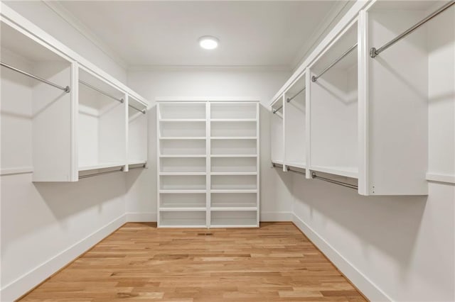 walk in closet with light hardwood / wood-style floors