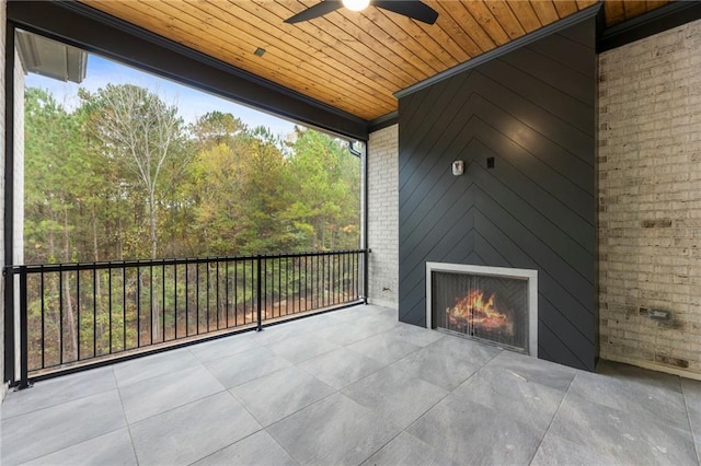 view of patio with ceiling fan and an outdoor fireplace