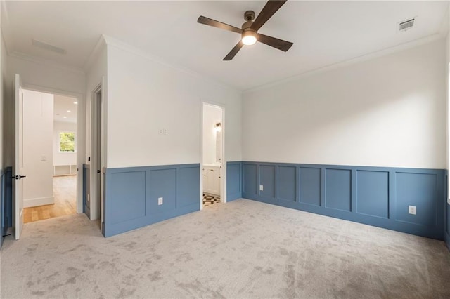 carpeted spare room with crown molding and ceiling fan