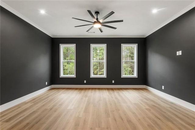 empty room with a healthy amount of sunlight, ornamental molding, and light hardwood / wood-style flooring