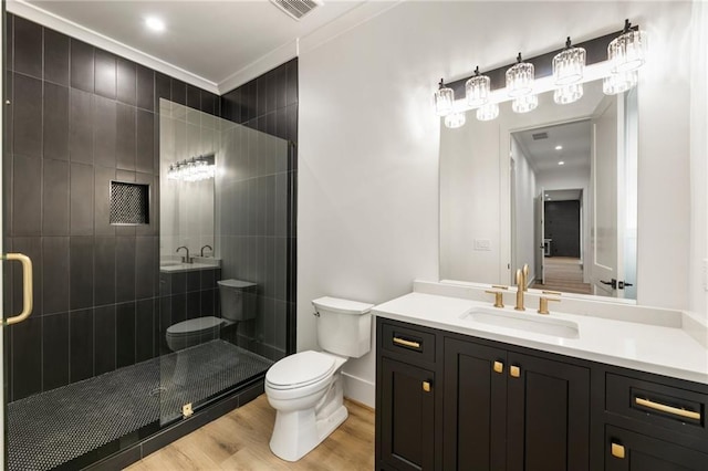 bathroom with vanity, a shower with door, crown molding, wood-type flooring, and toilet