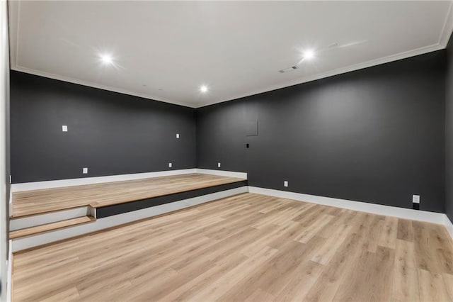 empty room featuring light wood-type flooring and ornamental molding