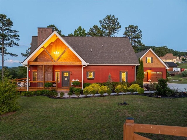 view of front of house featuring a yard, a porch, and a garage