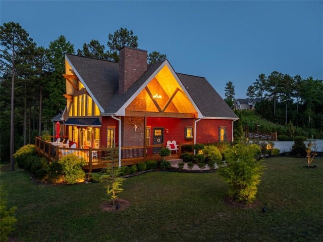 back of property featuring a lawn and a deck