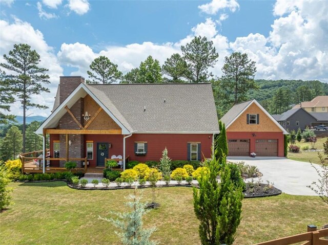 view of front of home featuring a porch, a garage, and a front lawn