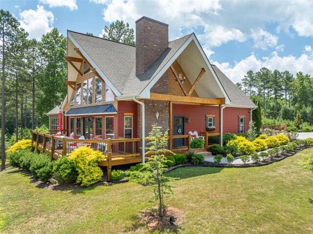 back of house with a deck and a yard