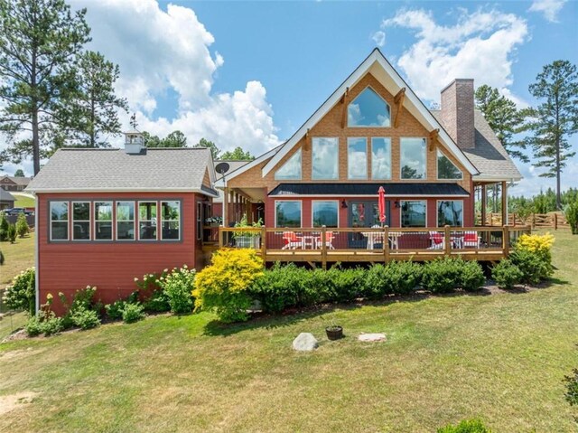 rear view of house featuring a deck and a yard