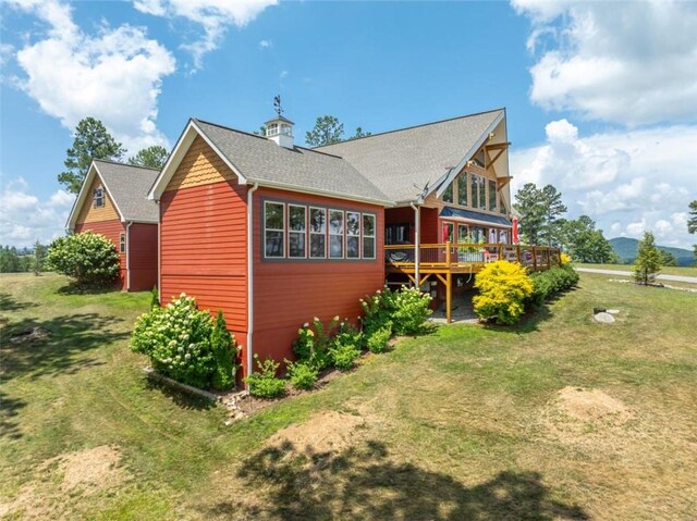 view of home's exterior with a lawn and a deck