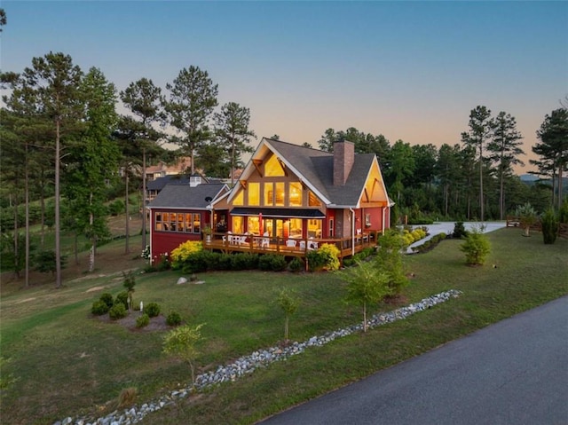 view of front of home with a deck and a yard