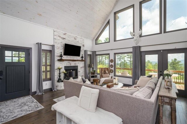 living room with high vaulted ceiling, wooden ceiling, a large fireplace, french doors, and dark hardwood / wood-style floors