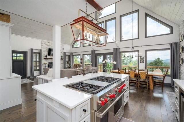 kitchen with white cabinetry, high vaulted ceiling, a kitchen island, an inviting chandelier, and double oven range