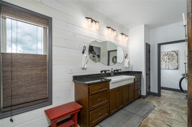 bathroom featuring wooden walls and vanity