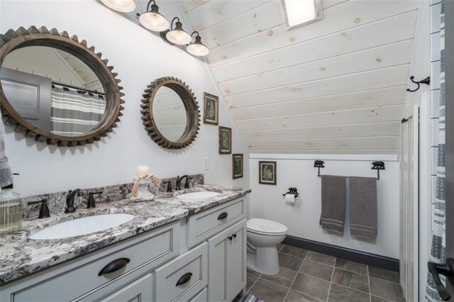 bathroom with vaulted ceiling, vanity, tile patterned flooring, and toilet