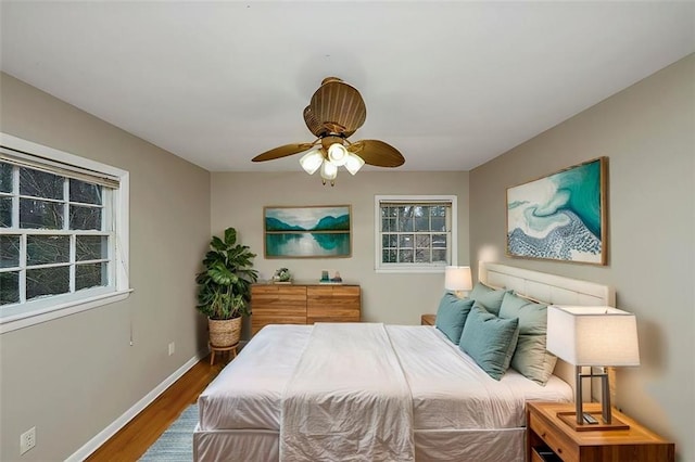 bedroom with hardwood / wood-style flooring, ceiling fan, and multiple windows