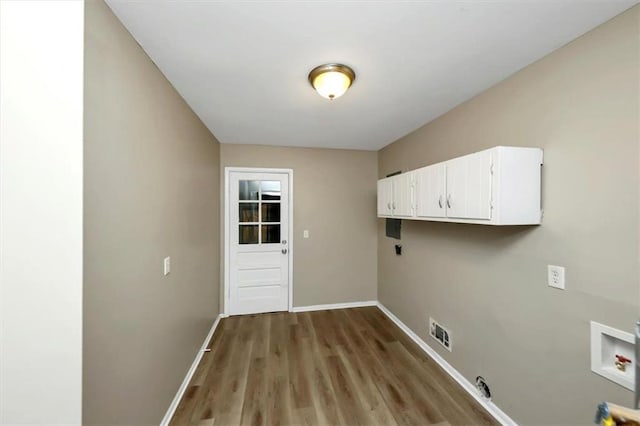 clothes washing area with gas dryer hookup, cabinets, hookup for a washing machine, electric dryer hookup, and light wood-type flooring