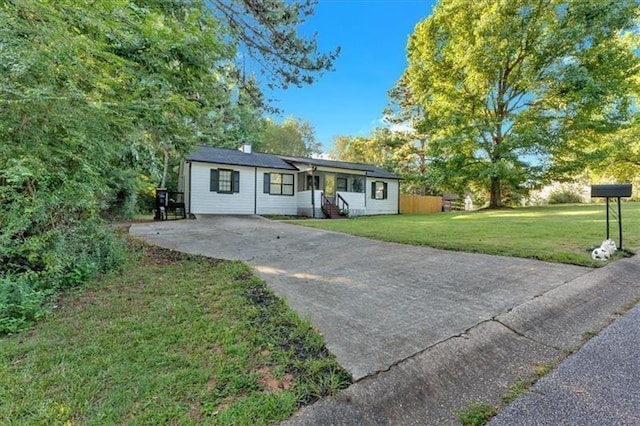 ranch-style house featuring driveway, a front lawn, and entry steps