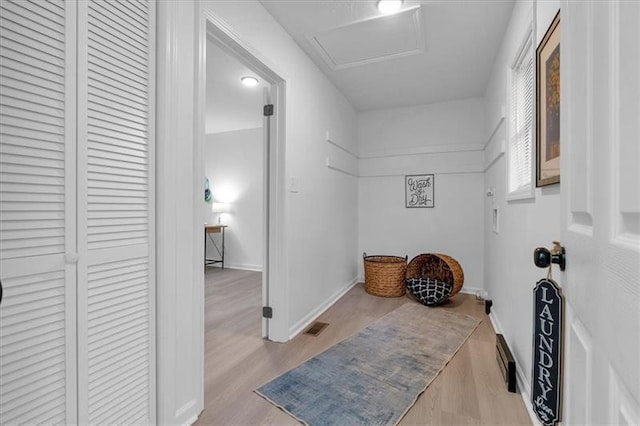 interior space with visible vents, wood finished floors, attic access, and baseboards