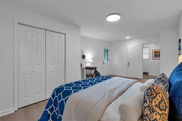 bedroom featuring a closet, wood finished floors, and baseboards