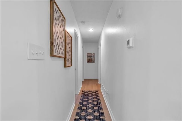 corridor with light carpet and baseboards