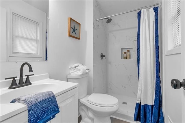 full bath featuring toilet, a marble finish shower, and vanity