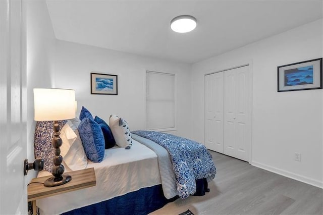 bedroom featuring a closet, baseboards, and wood finished floors