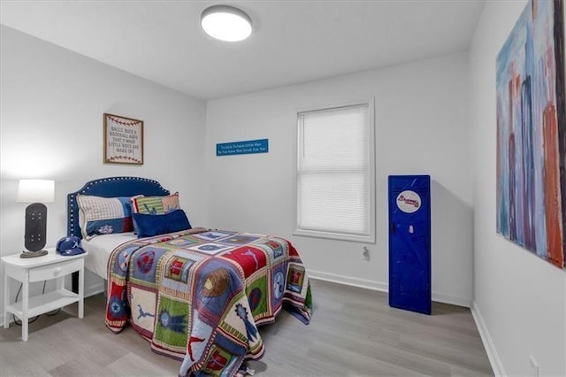 bedroom with baseboards and wood finished floors