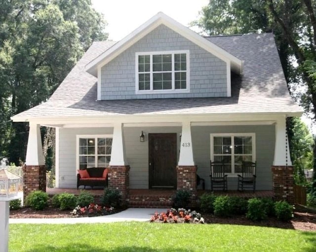 craftsman-style home with covered porch and a front lawn