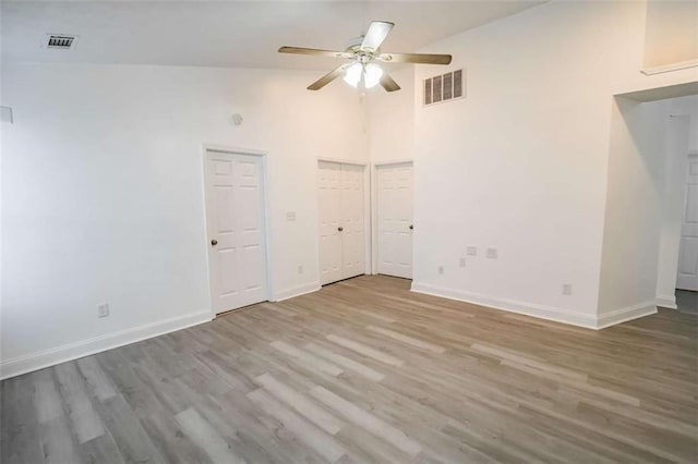 interior space featuring baseboards, ceiling fan, wood finished floors, and visible vents
