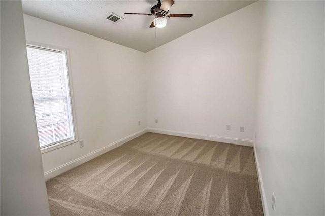 spare room with visible vents, a ceiling fan, baseboards, and light colored carpet