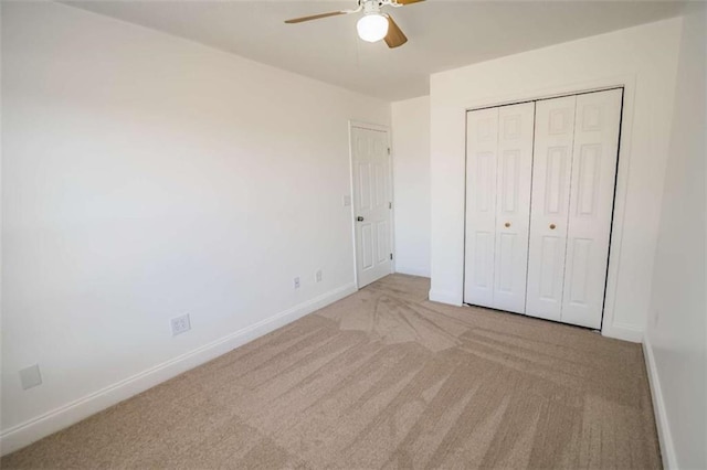unfurnished bedroom with carpet flooring, baseboards, ceiling fan, and a closet