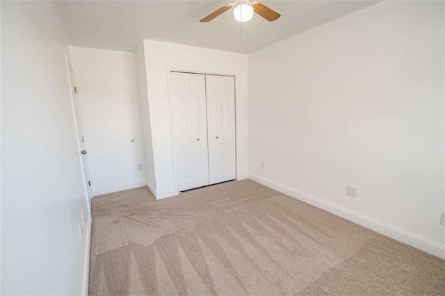unfurnished bedroom featuring baseboards, carpet, ceiling fan, and a closet