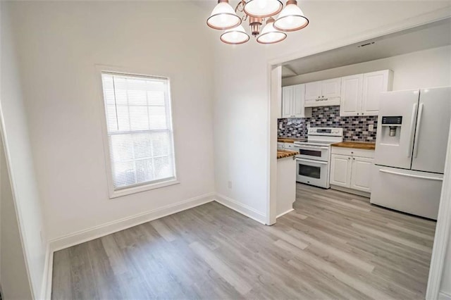 kitchen featuring range with two ovens, white refrigerator with ice dispenser, white cabinets, an inviting chandelier, and light wood-style flooring