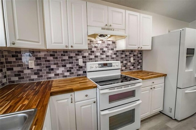 kitchen featuring white cabinets, under cabinet range hood, white appliances, and butcher block counters