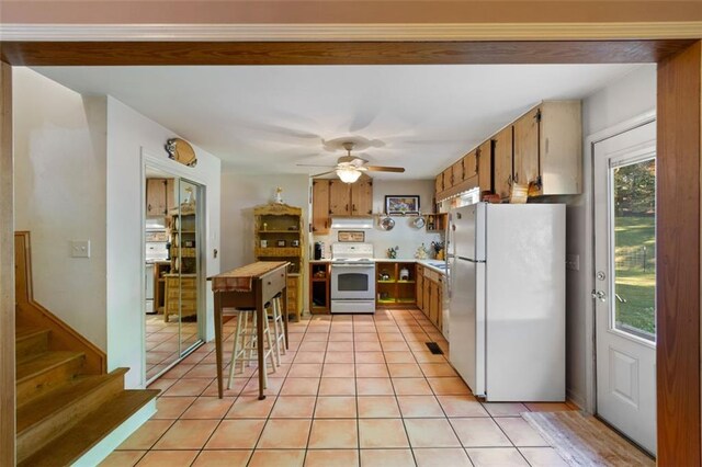 kitchen featuring white appliances, ceiling fan, and light tile patterned floors