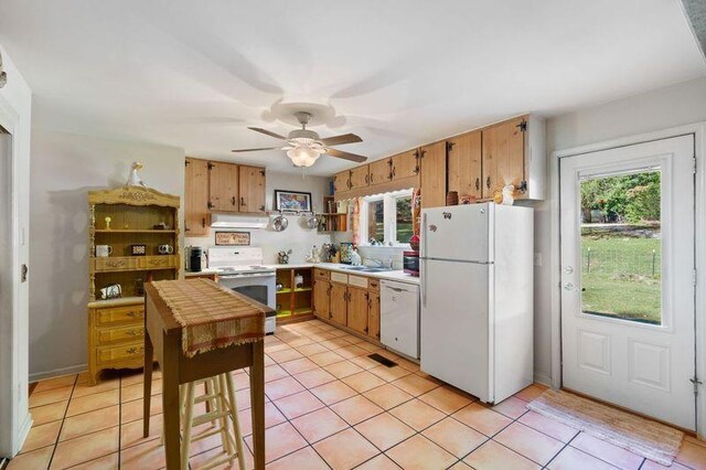 kitchen featuring white appliances, ceiling fan, sink, and light tile patterned floors