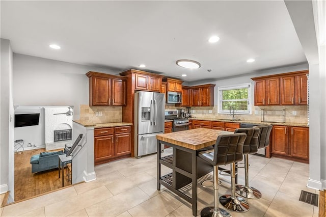 3307 Pointe Bleue Ct, Decatur, GA 30034 - kitchen with stainless steel appliances, backsplash, recessed lighting, brown cabinetry, and a sink