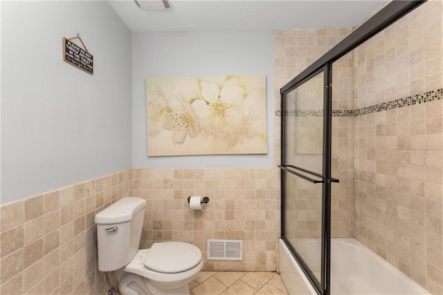 3307 Pointe Bleue Ct, Decatur, GA 30034 - bathroom featuring tile walls, toilet, bath / shower combo with glass door, tile patterned flooring, and wainscoting