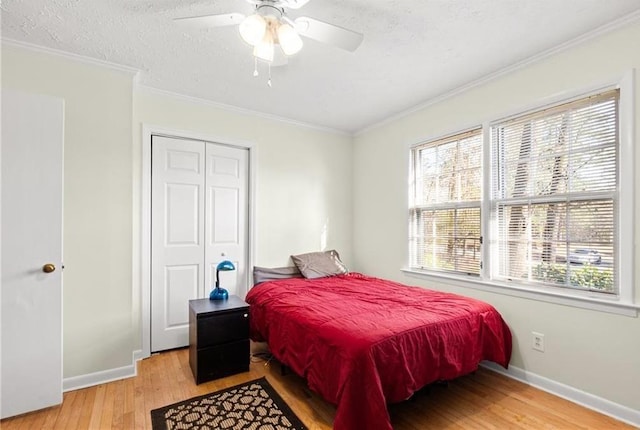 1729 Norden Rd, Riverdale, GA 30296 - bedroom with a closet, a textured ceiling, crown molding, baseboards, and light wood-type flooring