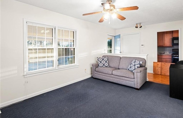 1729 Norden Rd, Riverdale, GA 30296 - living room with baseboards, ceiling fan, and dark carpet