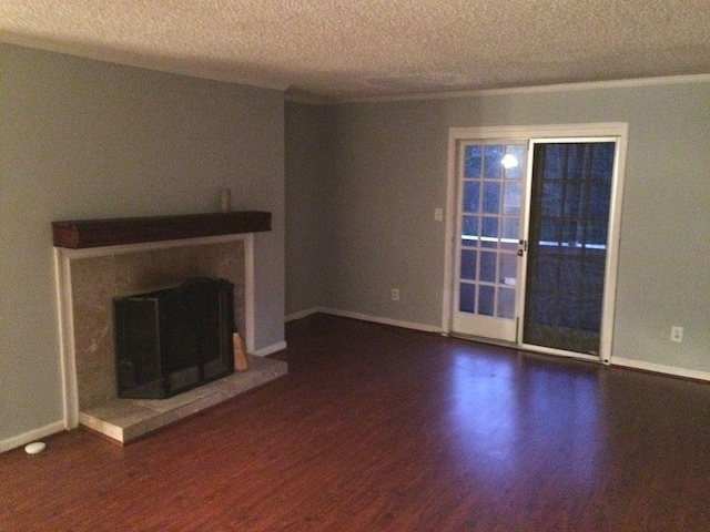 unfurnished living room featuring dark hardwood / wood-style flooring and a textured ceiling