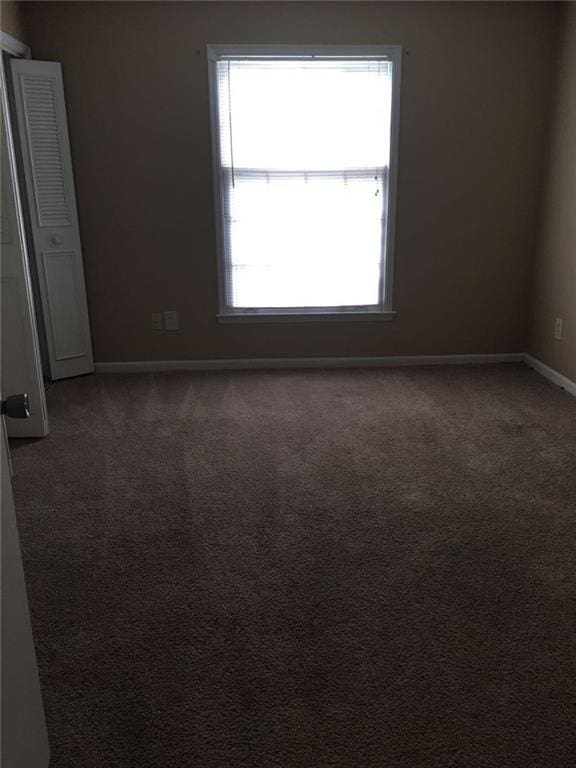 carpeted empty room featuring plenty of natural light