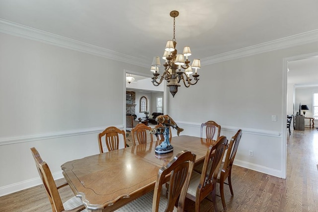 dining area featuring an inviting chandelier, crown molding, and wood-type flooring