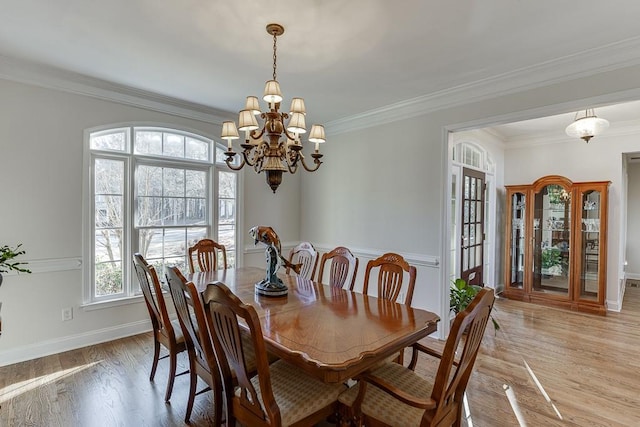 dining room featuring ornamental molding, light hardwood / wood-style floors, and a chandelier