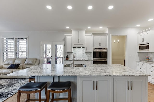 kitchen featuring sink, a breakfast bar, french doors, and appliances with stainless steel finishes