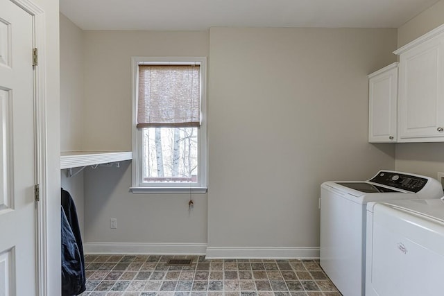 laundry room featuring washer and dryer and cabinets